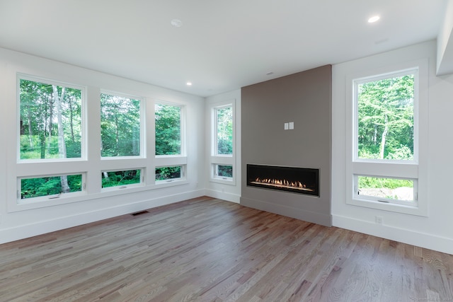 unfurnished living room with a wealth of natural light and light hardwood / wood-style flooring