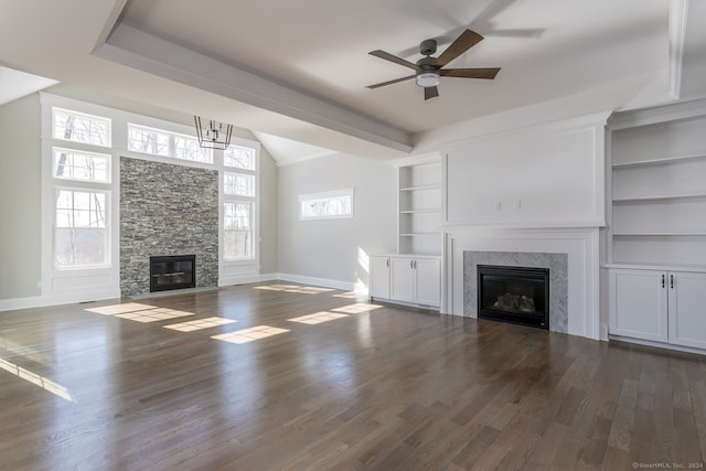 unfurnished living room with dark hardwood / wood-style flooring, a healthy amount of sunlight, built in shelves, and ceiling fan