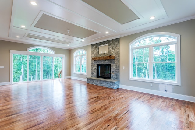 unfurnished living room featuring light wood-type flooring, ornamental molding, and a fireplace