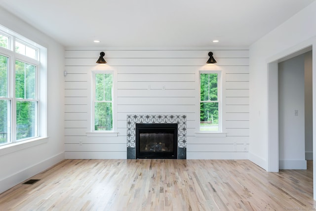 unfurnished living room with light wood-type flooring and a wealth of natural light