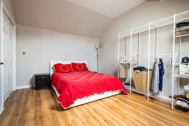 bedroom featuring lofted ceiling and hardwood / wood-style floors