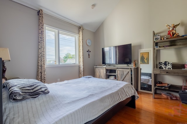 bedroom with lofted ceiling and hardwood / wood-style floors