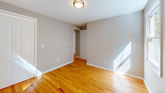 unfurnished bedroom featuring a closet and light hardwood / wood-style floors