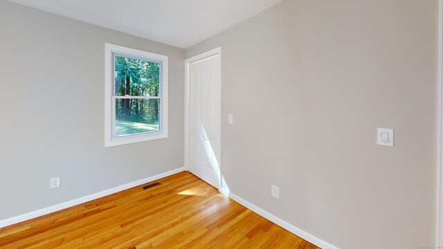 spare room featuring a healthy amount of sunlight and hardwood / wood-style flooring