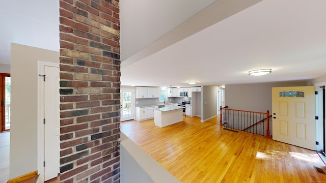 interior space featuring light wood-type flooring, appliances with stainless steel finishes, and white cabinetry