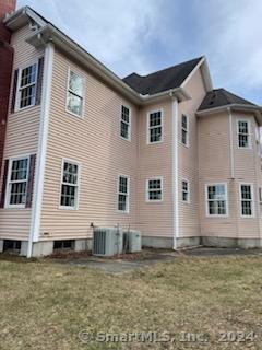 view of home's exterior featuring a lawn and central AC