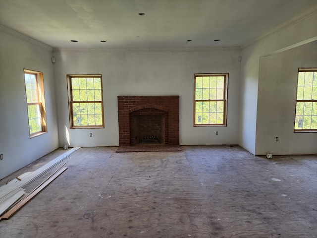 unfurnished living room with a wealth of natural light, a fireplace, and ornamental molding