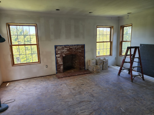 unfurnished living room featuring a fireplace, a wealth of natural light, and crown molding