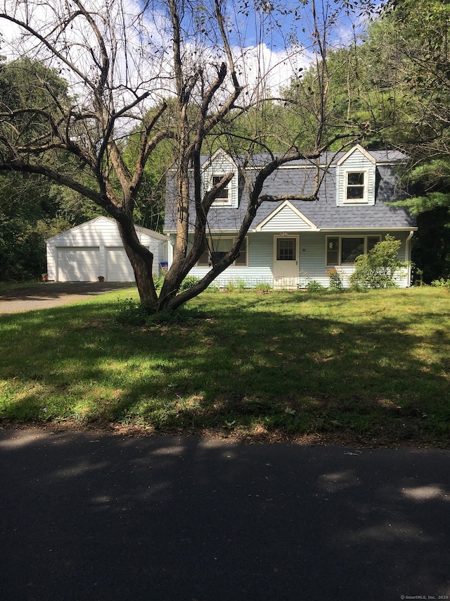 exterior space with a garage, a front yard, and an outbuilding