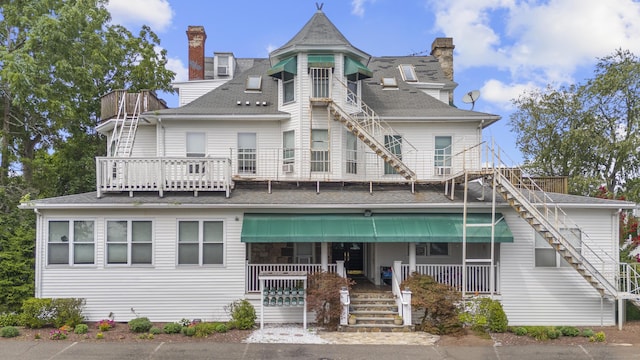 5 Hundley Ct Apt 1C, Stamford, CT 06902 - back of property featuring stairway, a chimney, covered porch, and roof with shingles