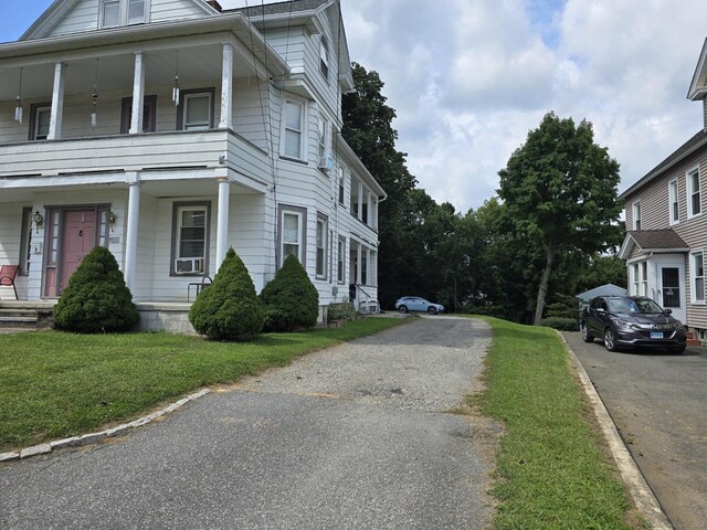 view of property exterior featuring a lawn and covered porch