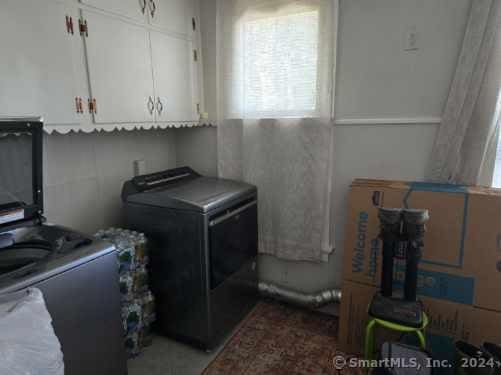 laundry area with cabinet space and washer / dryer