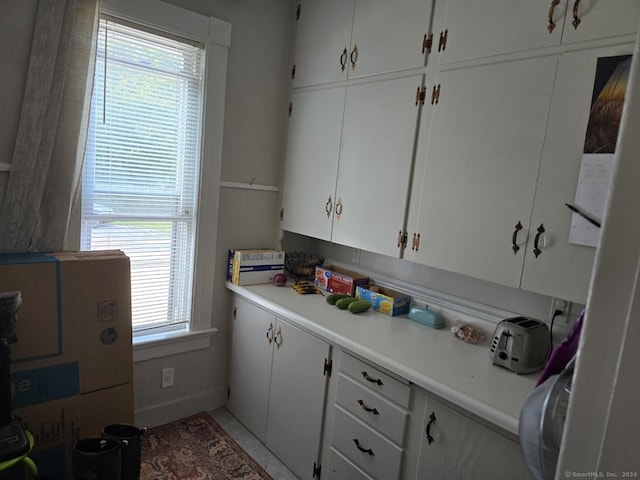 kitchen with light countertops, tile patterned flooring, and white cabinetry