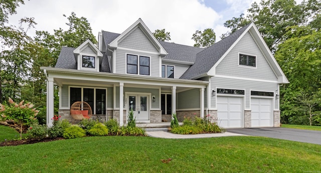 craftsman-style house with a porch, a front yard, and a garage