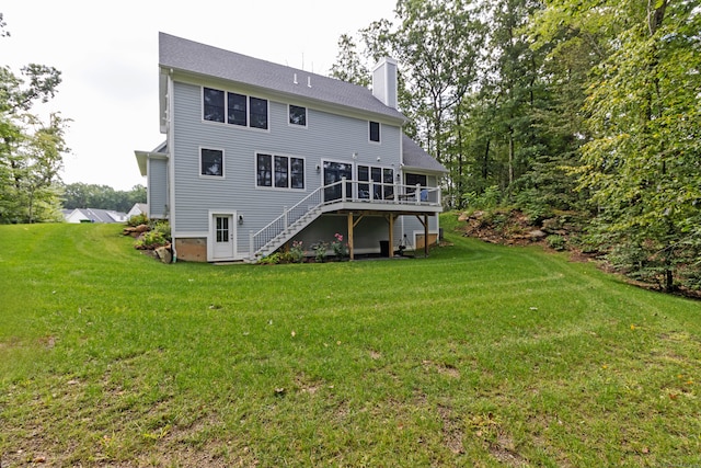 back of property featuring a wooden deck and a lawn