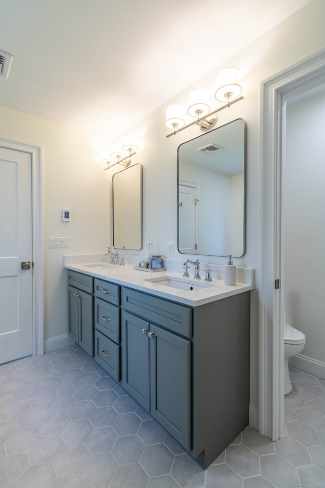 bathroom with vanity, toilet, and tile patterned flooring