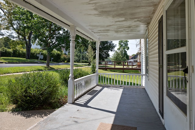 wooden terrace featuring a lawn