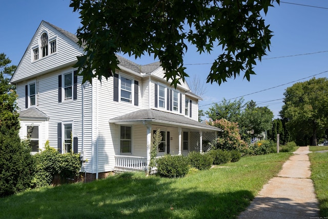 view of property exterior with covered porch and a lawn