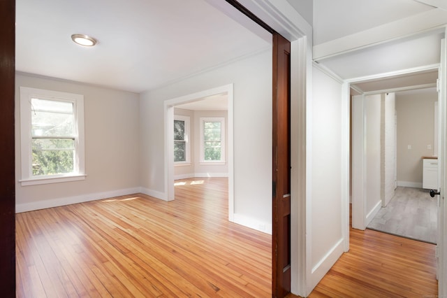 hallway with baseboards and light wood finished floors