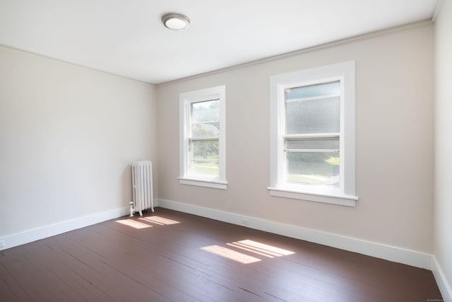 unfurnished room featuring radiator, wood-type flooring, and baseboards