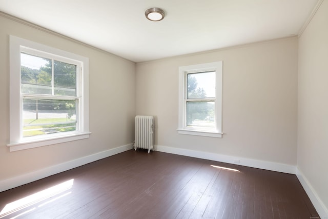 unfurnished room with baseboards, a healthy amount of sunlight, dark wood-style floors, and radiator