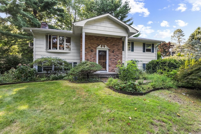 110 William St, Norwalk, CT 06851 - view of front of house with brick siding, a front yard, and a chimney