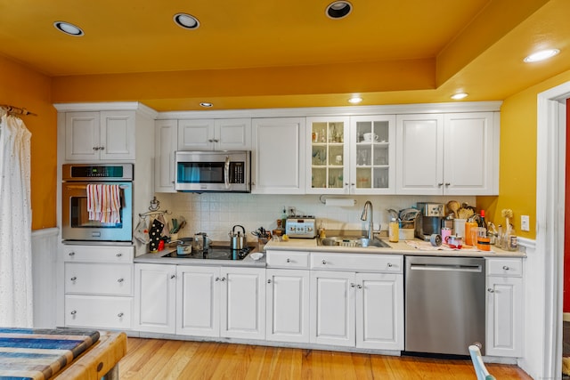 kitchen featuring light wood-type flooring, white cabinetry, stainless steel appliances, and sink