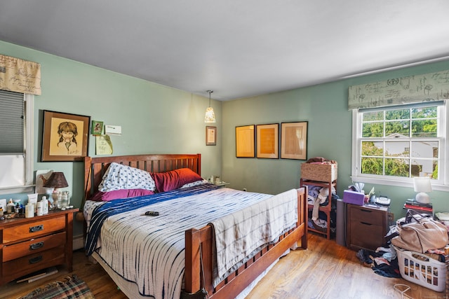 bedroom featuring baseboard heating and hardwood / wood-style floors