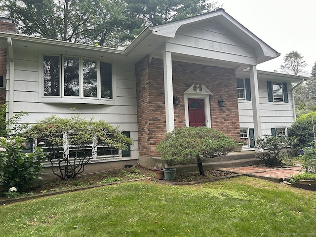 110 William St, Norwalk, CT 06851 - view of front of home featuring brick siding, a front lawn, and a chimney