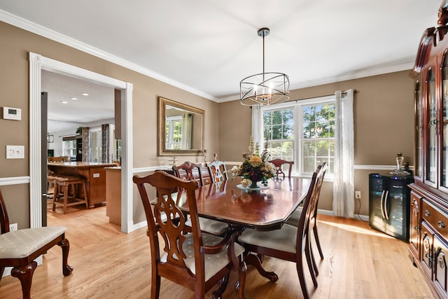 dining area featuring crown molding, light hardwood / wood-style flooring, and a notable chandelier