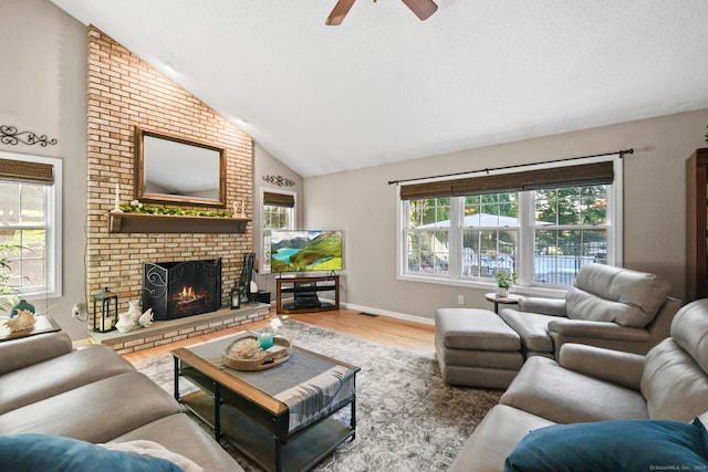 living room with hardwood / wood-style floors, a fireplace, high vaulted ceiling, and ceiling fan