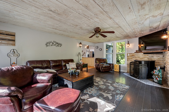 living room with dark wood-type flooring, ceiling fan, wooden ceiling, and a tiled fireplace