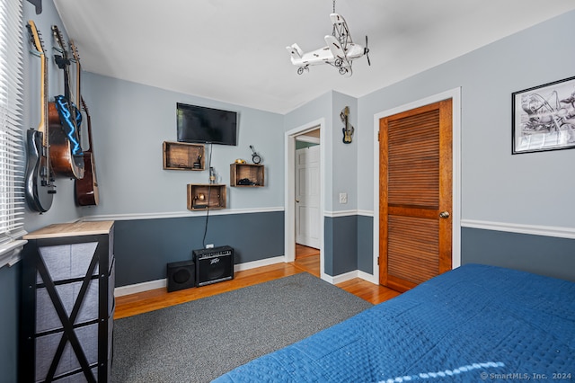 bedroom with a closet, hardwood / wood-style floors, and a chandelier