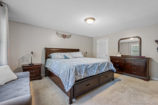 bedroom with light carpet and a textured ceiling