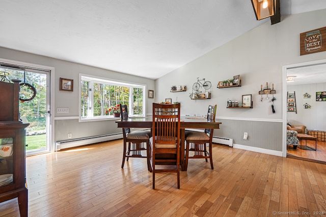 dining space with a baseboard radiator, lofted ceiling with beams, and light hardwood / wood-style flooring