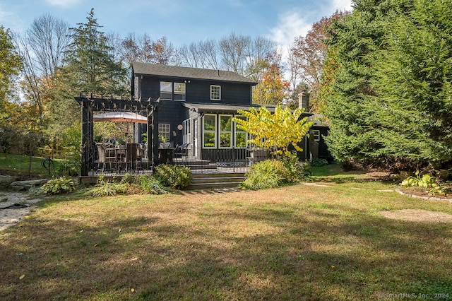 rear view of property featuring a yard, a deck, and a pergola