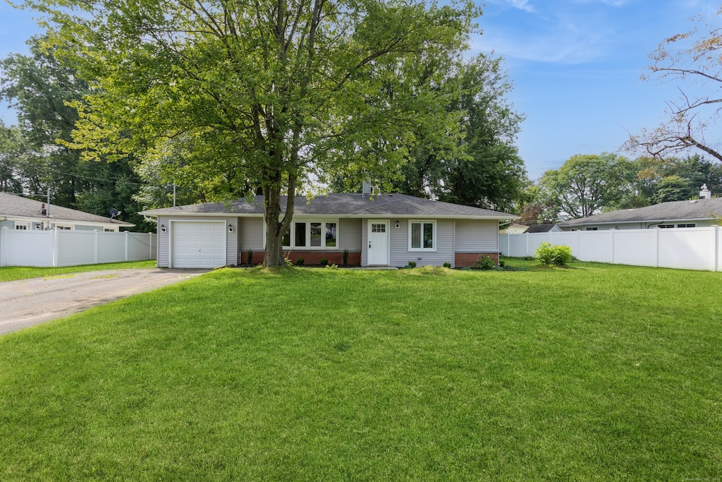 view of front of home with a garage and a front lawn