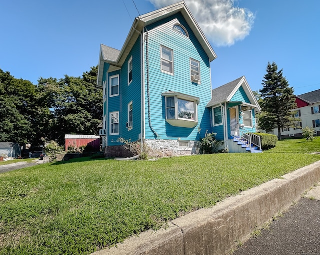 view of front facade featuring cooling unit and a front lawn