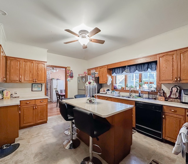 kitchen featuring stainless steel refrigerator, a kitchen island, sink, ceiling fan, and black dishwasher