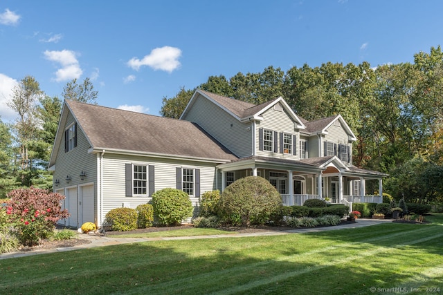 view of front of property with a front lawn, covered porch, and a garage