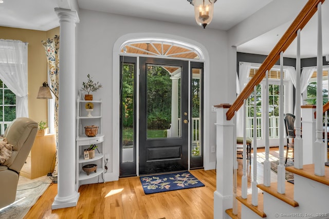 entrance foyer featuring decorative columns and light wood-type flooring