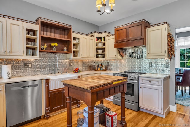 kitchen featuring tasteful backsplash, sink, light hardwood / wood-style floors, custom exhaust hood, and appliances with stainless steel finishes