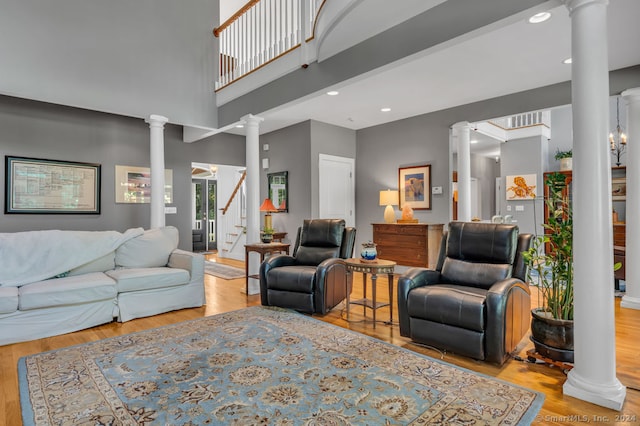 living room featuring ornate columns, beamed ceiling, and light hardwood / wood-style floors