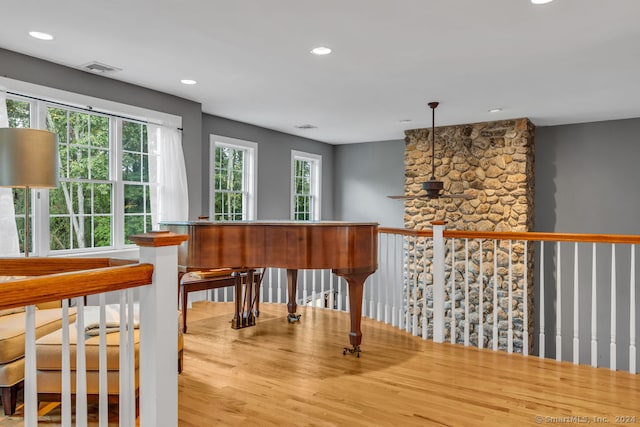 miscellaneous room featuring ceiling fan, a wealth of natural light, and light hardwood / wood-style floors