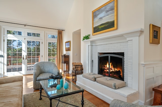 living room with hardwood / wood-style flooring, a fireplace, and high vaulted ceiling