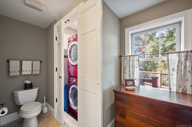 bathroom featuring toilet and stacked washing maching and dryer