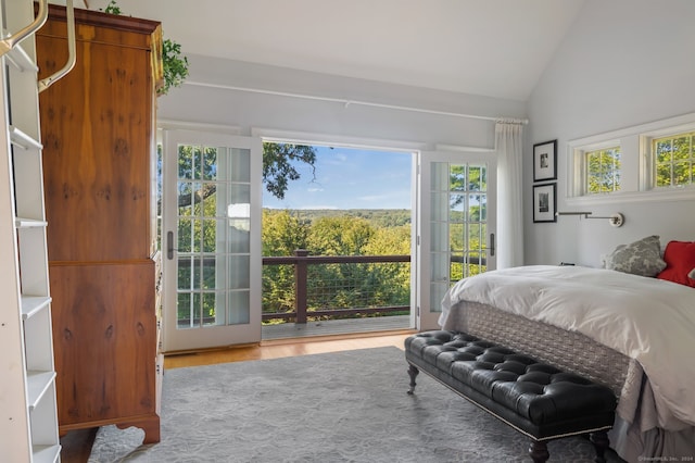 bedroom featuring vaulted ceiling, light hardwood / wood-style floors, and access to exterior