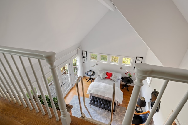 staircase featuring high vaulted ceiling, beam ceiling, and hardwood / wood-style floors