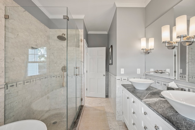 bathroom with ornamental molding, vanity, tile walls, and a shower with shower door