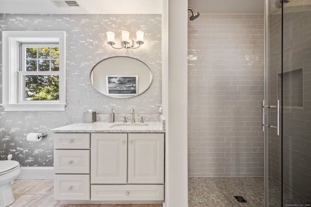 bathroom featuring tile patterned flooring, walk in shower, vanity, and toilet